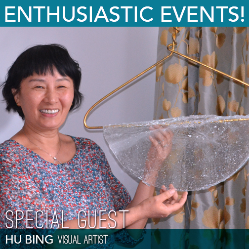 Visual Artist Hu Bing smiles next to one of her creations which includes an iron clothes hanger and blown glass